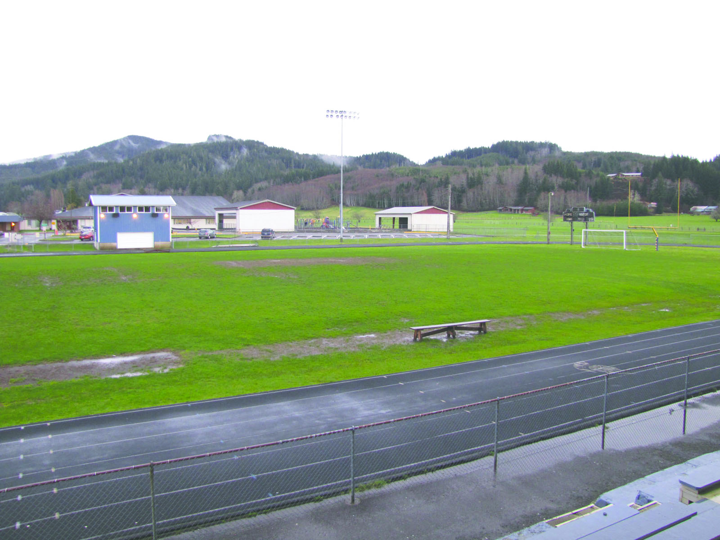 The muddy football field at Forks High School is expected to undergo a major transformation into a $1.25 million artificial turf field with a freshly resurfaced track this summer. (Arwyn Rice/Peninsula Daily News)