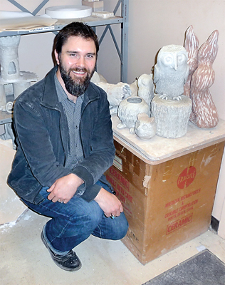 Ceramics instructor Jake Reichner poses with a brood of bird sculptures waiting to dry thoroughly before they can have their first firing in one of two kilns in his classroom. (Olympic Peninsula News Group)