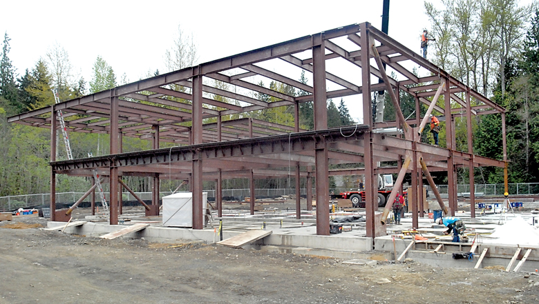 Workers erect the framework for what will become the new Allied Health and Early Childhood Development Center on the Port Angeles campus of Peninsula College on Tuesday. — Keith Thorpe/Peninsula Daily News ()