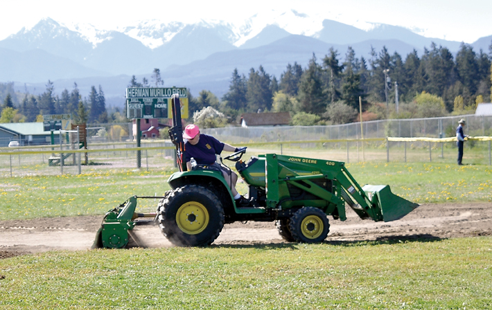 Rotarian Steve Gale churns up infield dirt at one of the Sequim Little League fields at Dr. James Standard Park in Sequim. — Michael Dashiell/Olympic Peninsula News Group ()