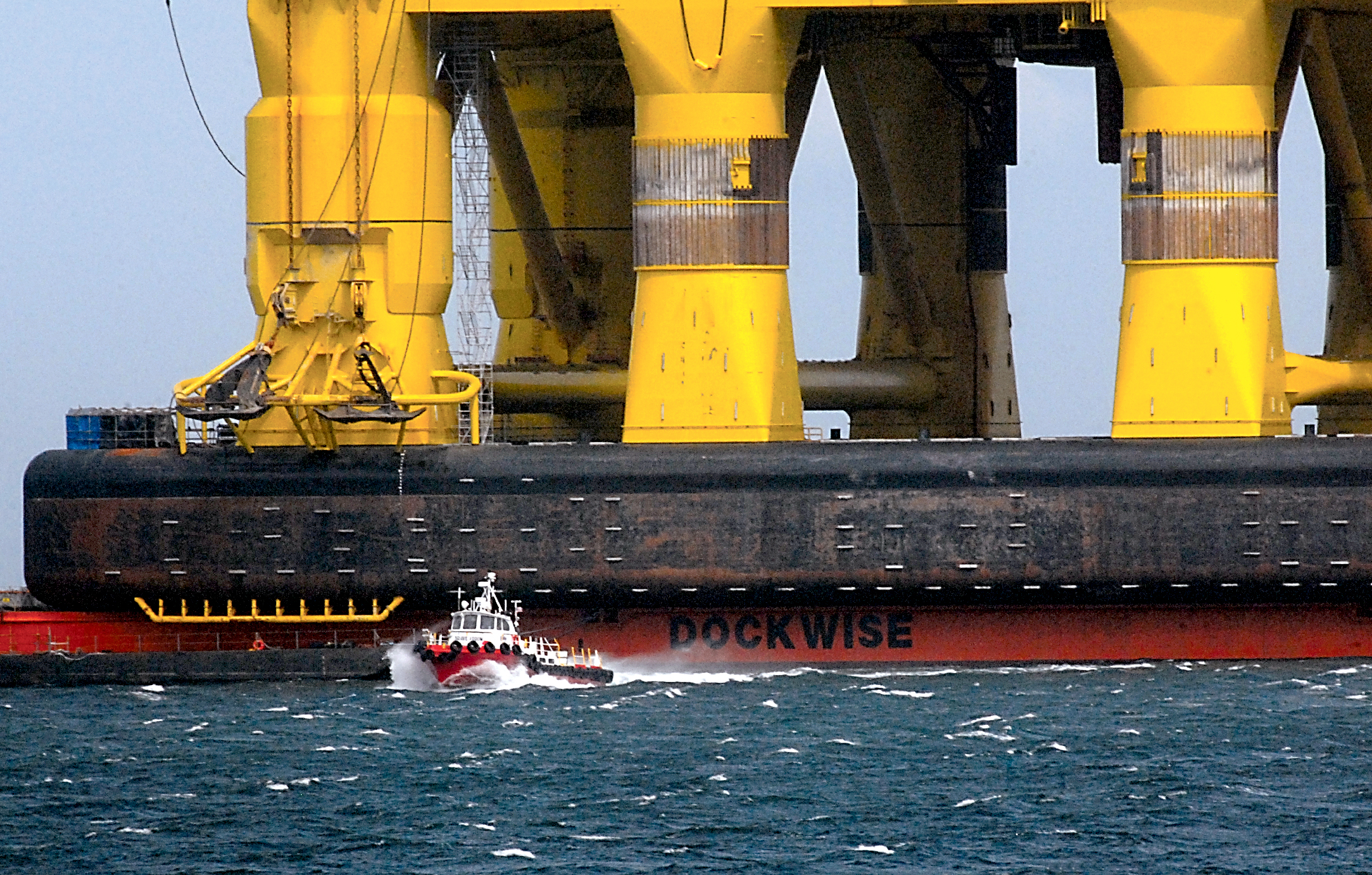 The Port Angeles-based launch Brave Arrow departs the Polar Pioneer offshore oil platform atop the MV Blue Marlin cargo deck ship as it shuttles workers to shore in Port Angeles Harbor on Tuesday. (Keith Thorpe/Peninsula Daily News)