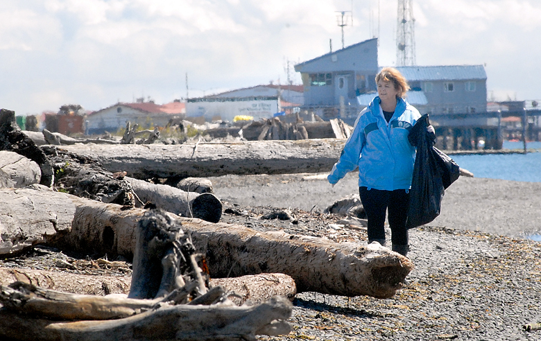 Lori Taylor of Port Angeles looks for litter and debris along Ediz Hook on the shore of Port Angeles Harbor during last year’s beach cleanup event. — Keith Thorpe/Peninsula Daily News ()