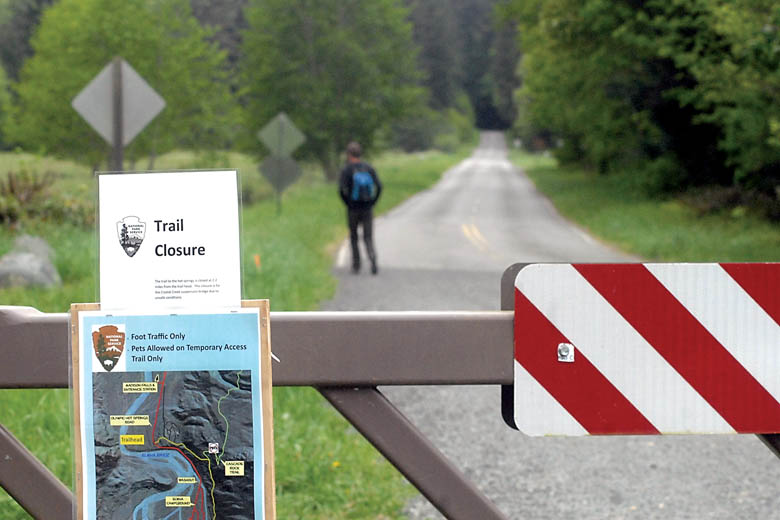 A trail closure sign and temporary trail map are affixed to a gate blocking Olympic Hot Springs Road into Olympic National Park in the Elwha Valley west of Port Angeles on Thursday. — Keith Thorpe/Peninsula Daily News ()