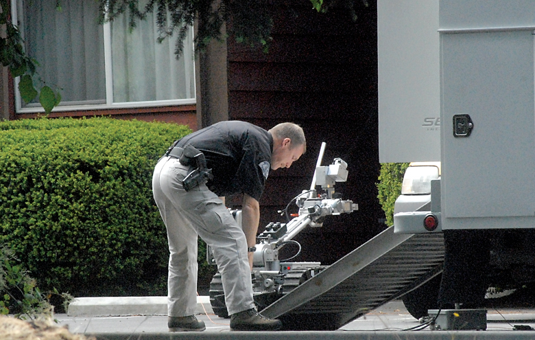 Keith Nestor of the Washington State Patrol bomb squad prepares a robotic vehicle to enter an apartment at 1019 W. 18th St.