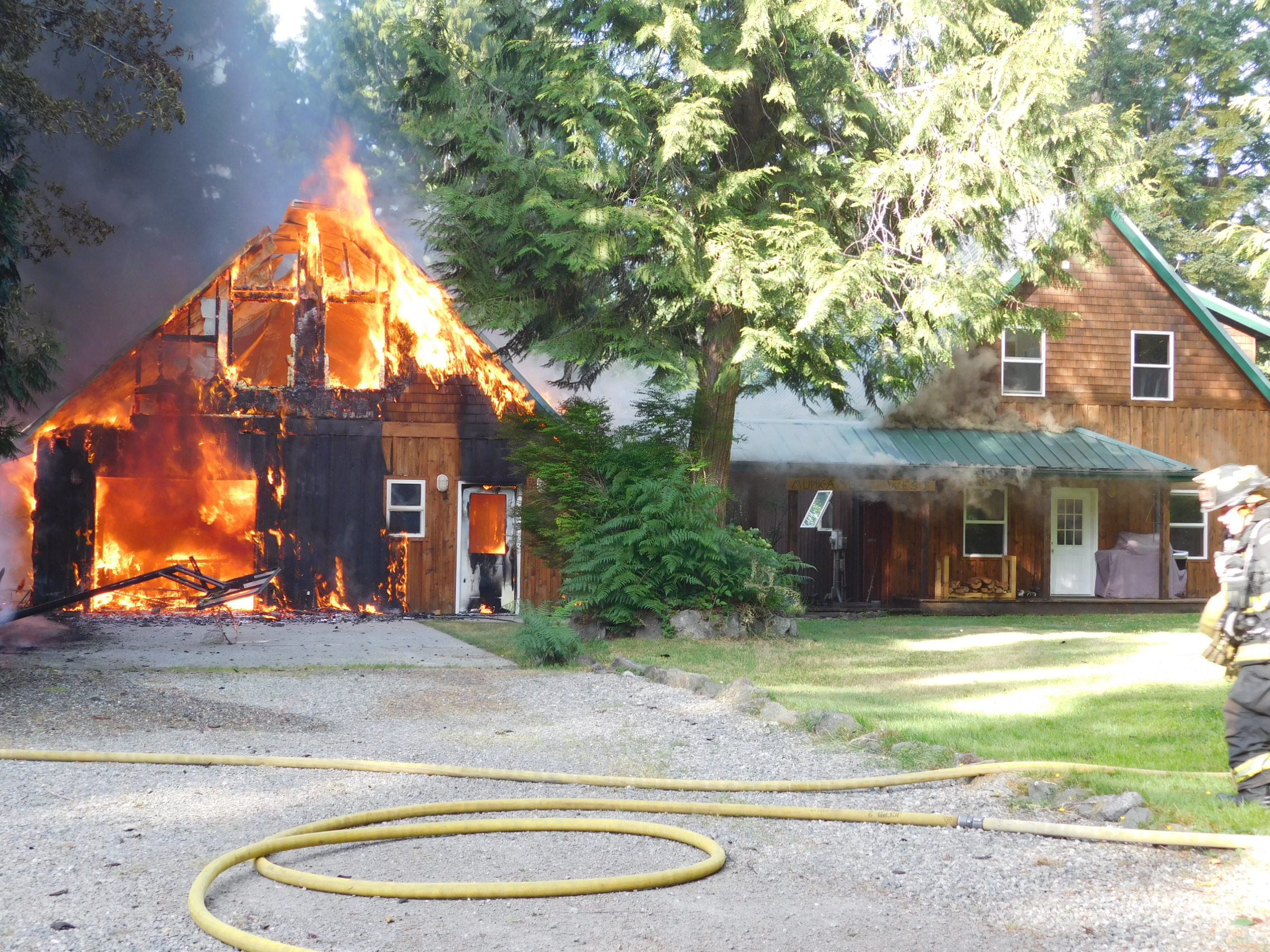 A garage is engulfed in flames Monday at a property in Coyle. (Denise Karp/Quilcene Fire Rescue)
