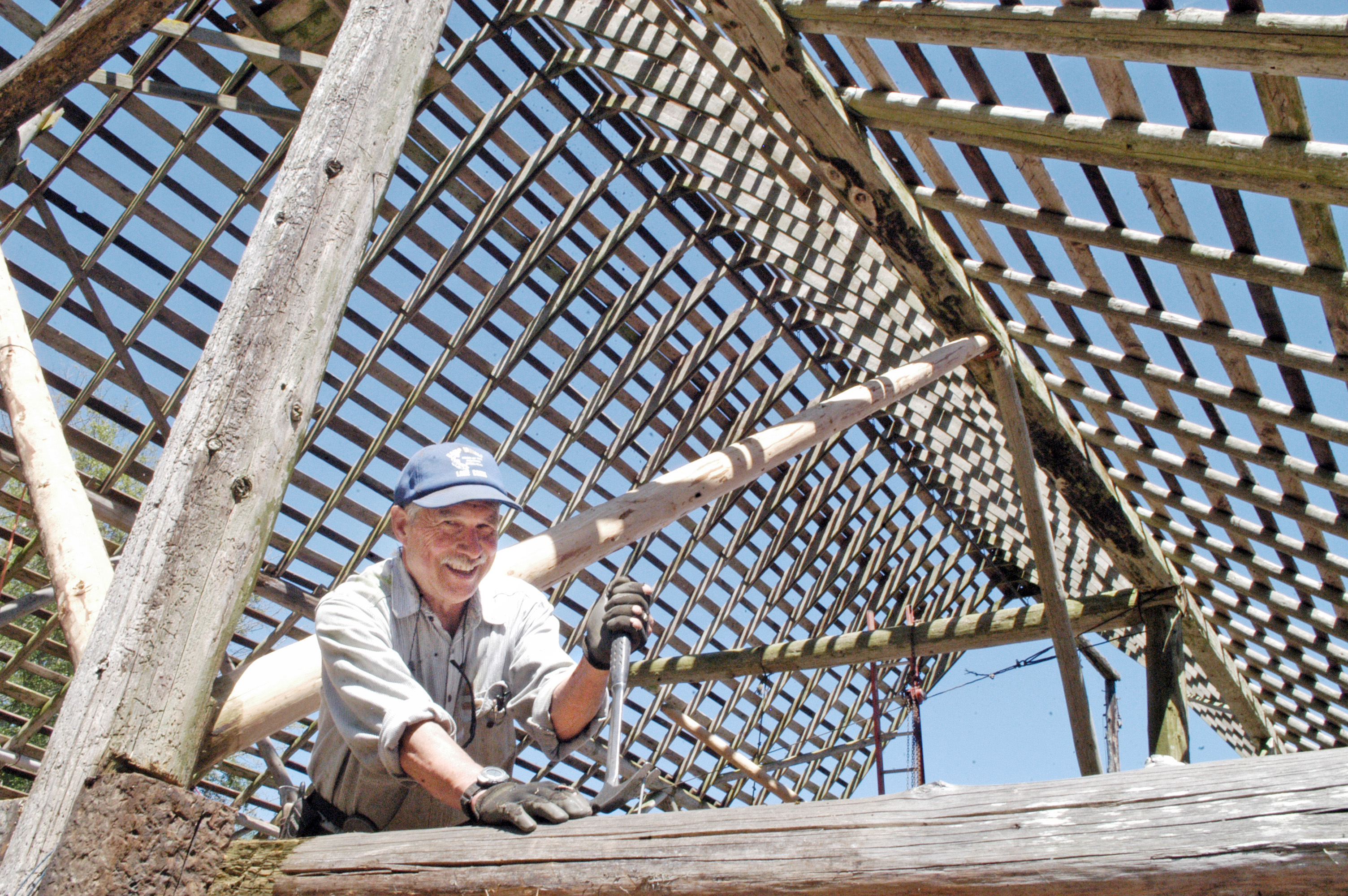 Paul Hansen pulls out a nail from a beam in the Henry Frost Barn on Wednesday morning. — Chris McDaniel/Peninsula Daily News ()