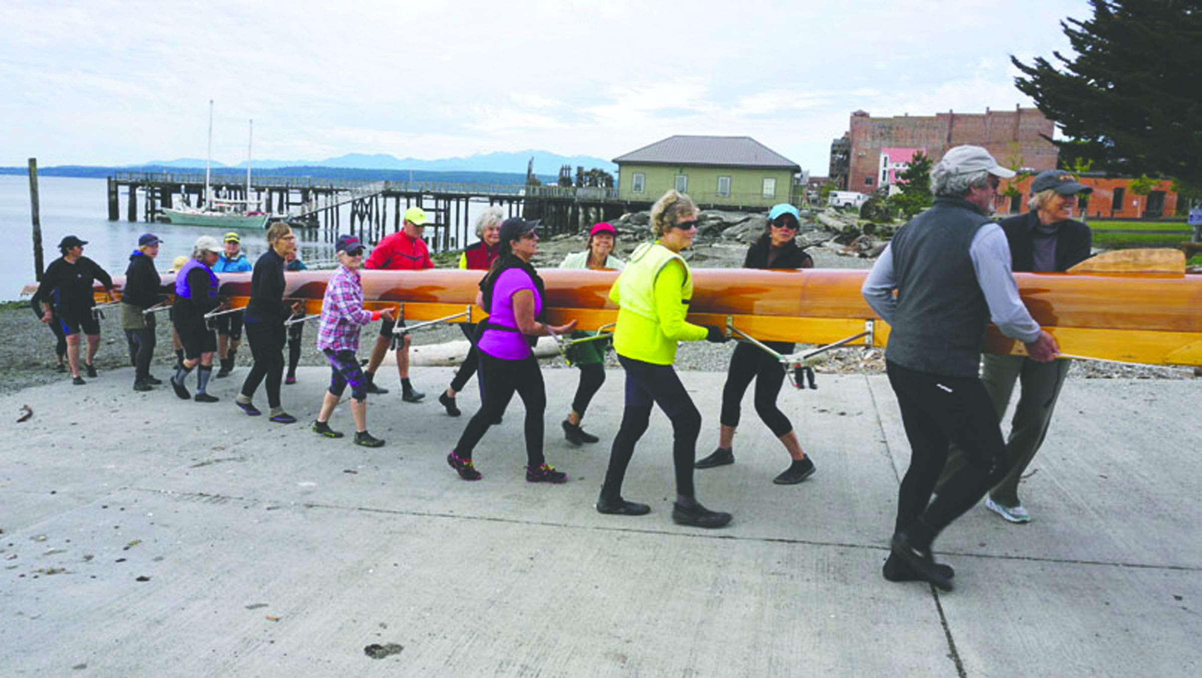 Members of the Rat Island Rowing and Sculling Club carry the Kathy Lazara Whitman