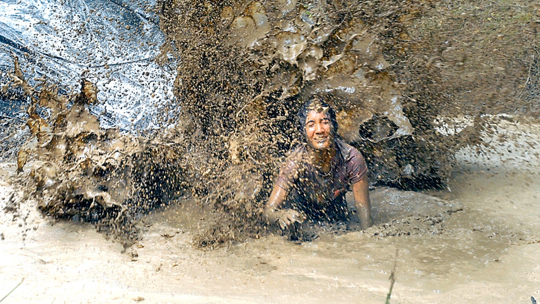 Alyssa Pelayo of Hong Kong gets splattered with mud while trying to emerge from a mud puddle at the base of the “slip and slide” obstacle at the Extreme Sports Park in Port Angeles last year. (Keith Thorpe/Peninsula Daily News)
