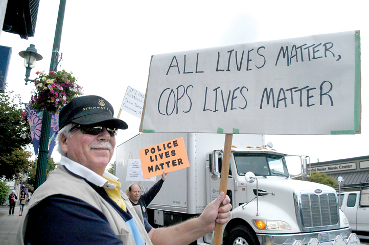 Peter Heisel of Sequim participates in a rally for police in the wake of an attack in Dallas in which five police officers were gunned down by a sniper. In the background is Gil Loujan of Port Angeles. (Chris McDaniel/Peninsula Daily News)