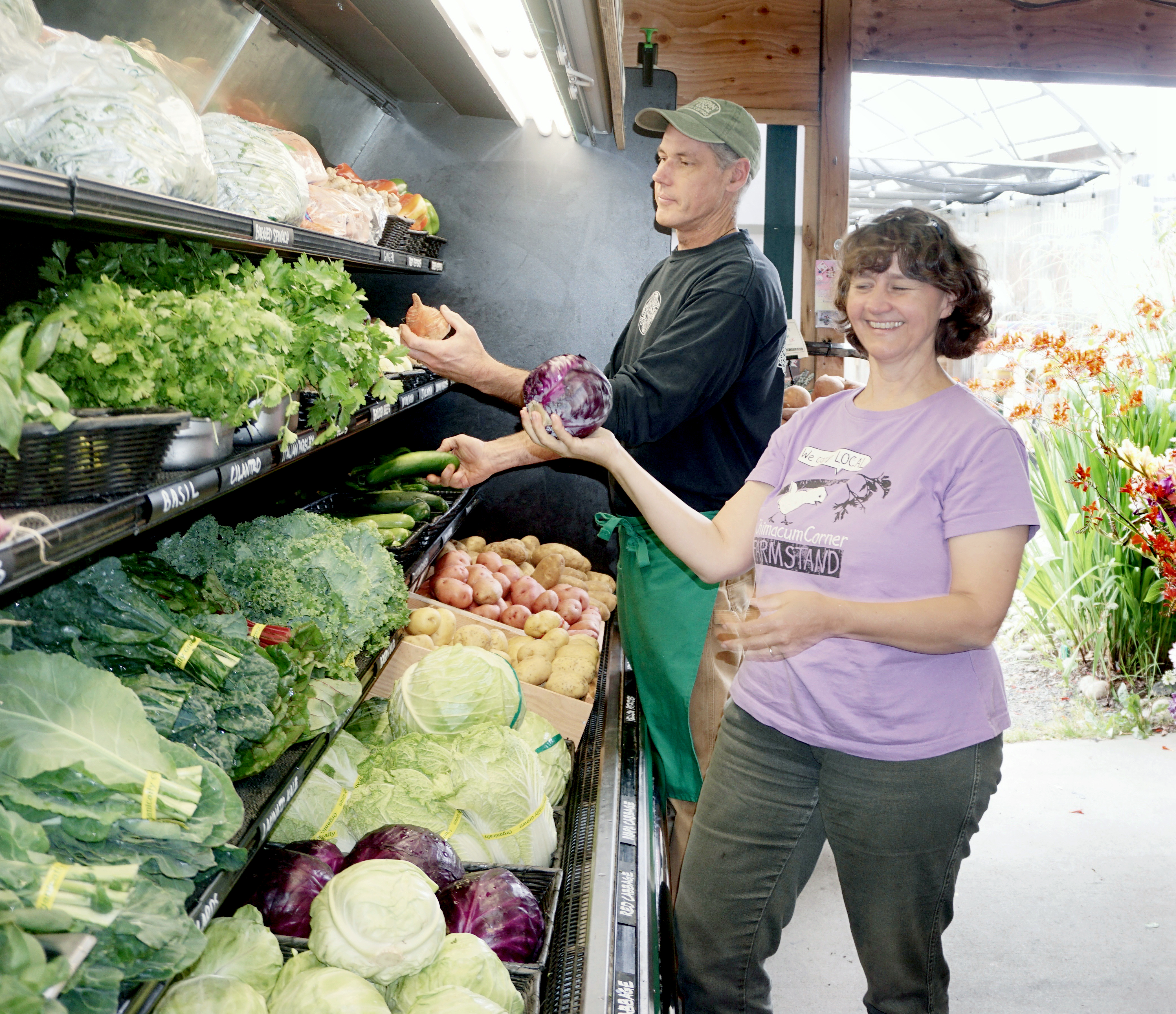 Chimacum Corner Farmstand general manager Rob Story and grocery manager Kristin Berg arrange some of the business’ fresh produce. — Charlie Bermant/Peninsula Daily News ()