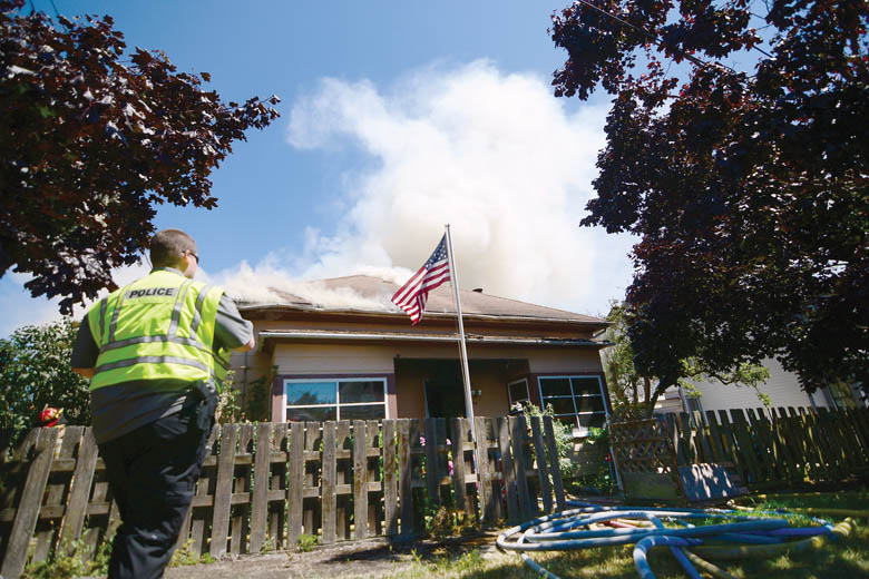 Smoke pours out of the Port Townsend home that caught fire Thursday afternoon. (Jesse Major/Peninsula Daily News)