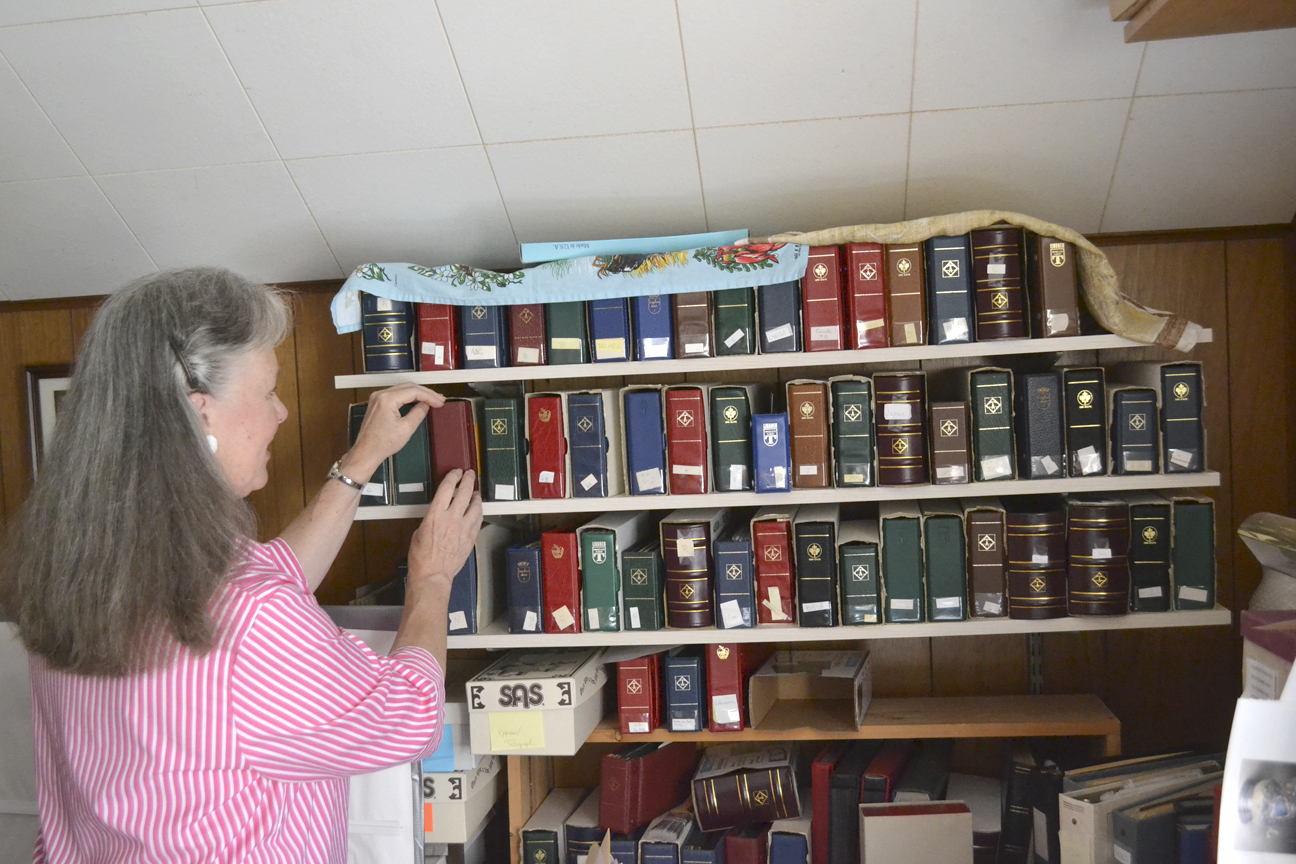 Sequim stamp collector Cathie Osborne pulls out some of her books holding stamps from all over the world. Her main focus is bell stamps