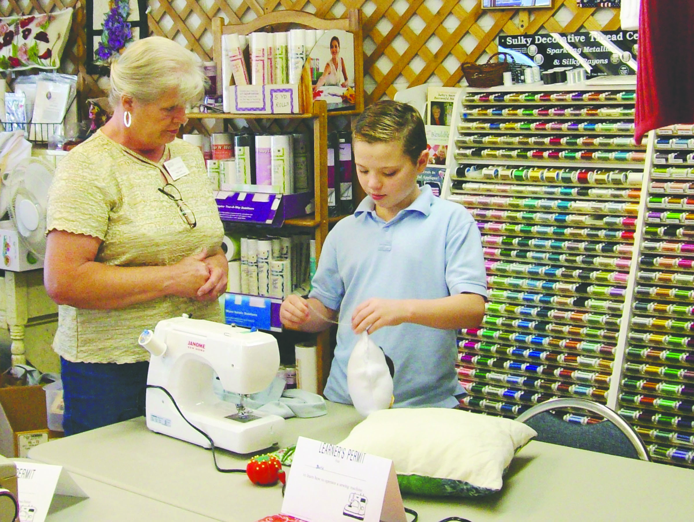 Trisha Franklin helps Davis Hueter with a sewing project at the second annual Clallam County 4-H and Washington State University clothing textile advisers Sewing Camp.