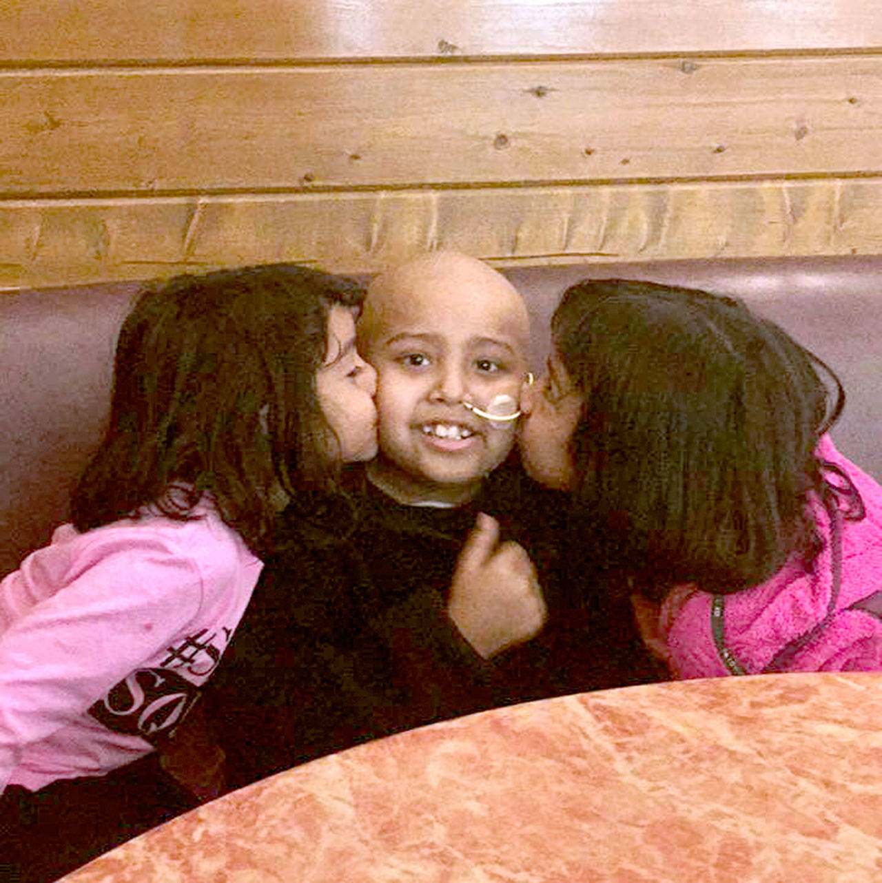 Sisters Kendra and Kimberly give their brother, Orlando, a kiss on the cheek. (Ireni Ramos)