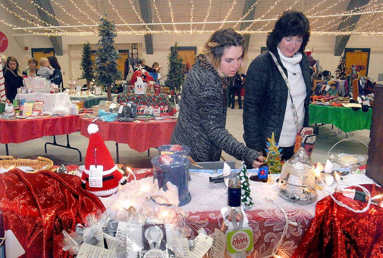 Monica Russell, left, and her aunt, Gail McDonald, both of Port Angeles, examine a table filled with holiday crafts at the 37th annual edition of the Original Christmas Cottage craft fair last weekend at Vern Burton Community Center in Port Angeles. Holiday bazaars continue this weekend across the North Olympic Peninsula. (Keith Thorpe/Peninsula Daily News)