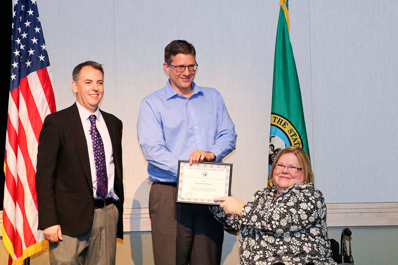 Mike LaGrange, center, who manages the Safeway on Lincoln Street in Port Angeles, receives a certificate for the Governor’s 2017 Medium Private Employer of the Year for the grocery store’s efforts to hire people with disabilities. (Safeway)