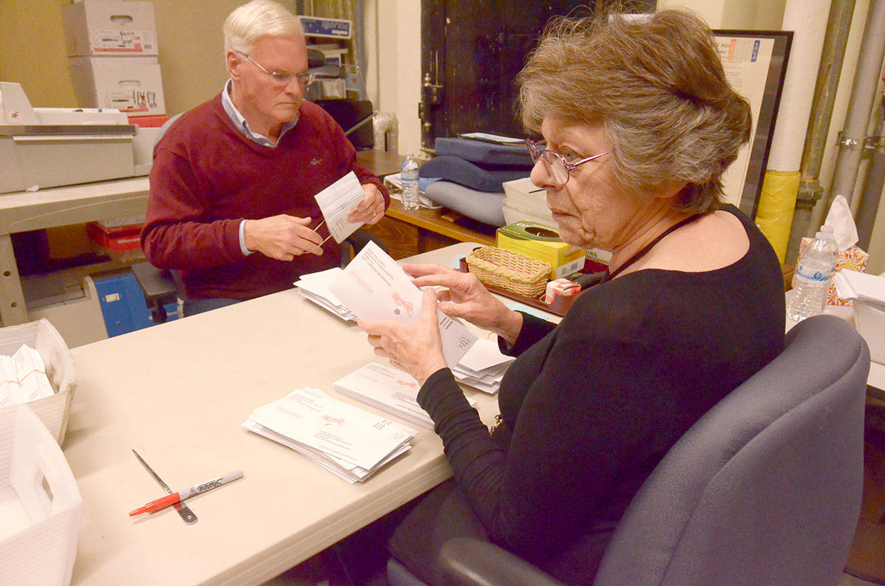 Laurie Meyer and Jay Page help process ballots already mailed in before the Nov. 7 deadline at the Jefferson County Courthouse. (Cydney McFarland/Peninsula Daily News)