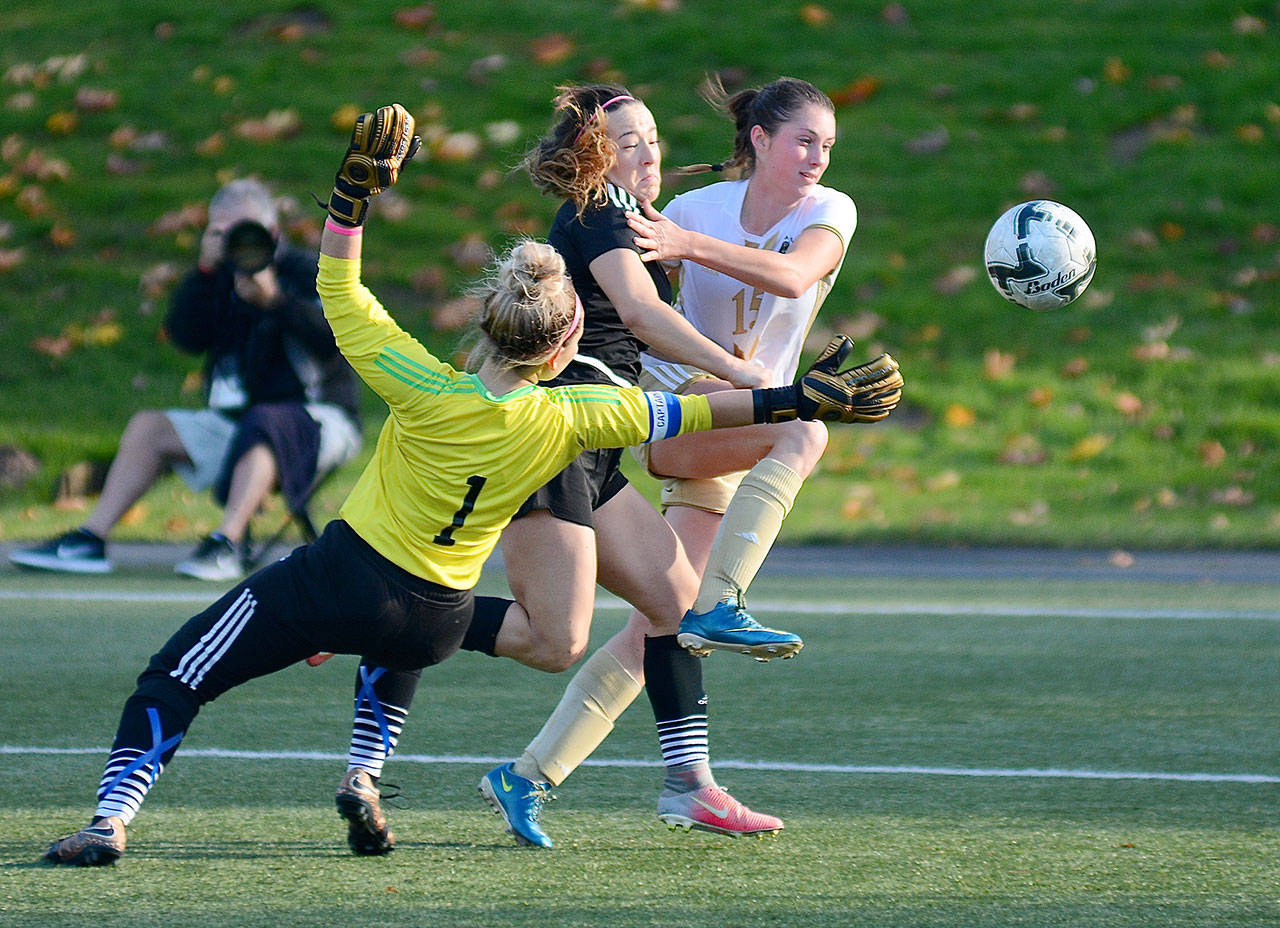 Peninsula College’s Sydney Warren fends off a Titans defender and goaltender Jenna Poland during the Pirates’ 4-0 win over the Trojans on Thursday in the Northwest Athletic Conference semifinals. The Peninsula women play Highland in the NWAC championship at 2:30 p.m. today. (Jay Cline/for Peninsula Daily News)