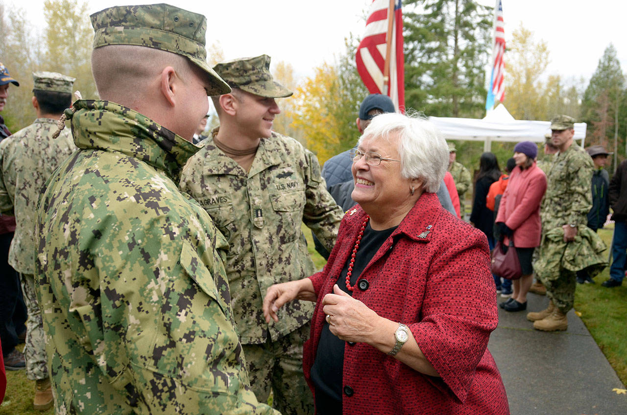 Joan Shields Bennett, widow of Navy Seabee Medal of Honor recipient Marvin G. Shields, hugs and talks with Lt. Justin Austin, left, and Lt. Zach Seagraves, center after a Veterans Day event to honor her late husband at the Gardiner Cemetery on Saturday. (Cydney McFarland/Peninsula Daily News)
