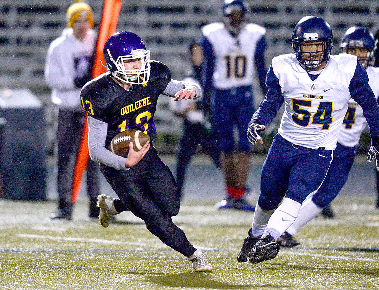 Quilcene running back Olin Reynolds(13) runs away from Tacoma Baptist’s So Ktongryoon (54) Saturday night in Poulsbo. (Jeff Halstead/for Peninsula Daily News)