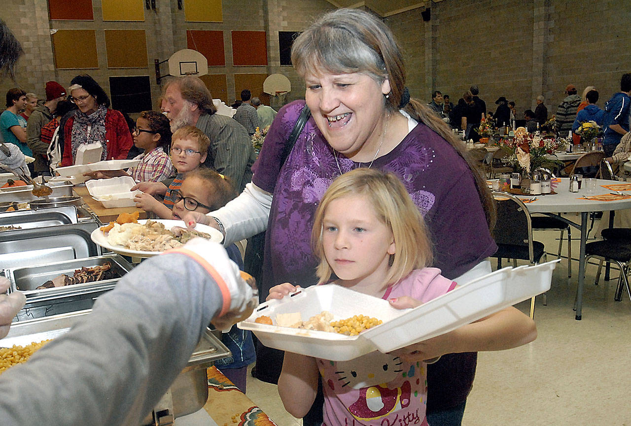 Lynette Schaner of Port Angeles and her granddaughter, Kalika Mulvaine, then 10, go through the serving line during the 2016 community Thanksgiving dinner in the gym of Queen of Angels Catholic Church in Port Angeles. (Keith Thorpe/Peninsula Daily News)