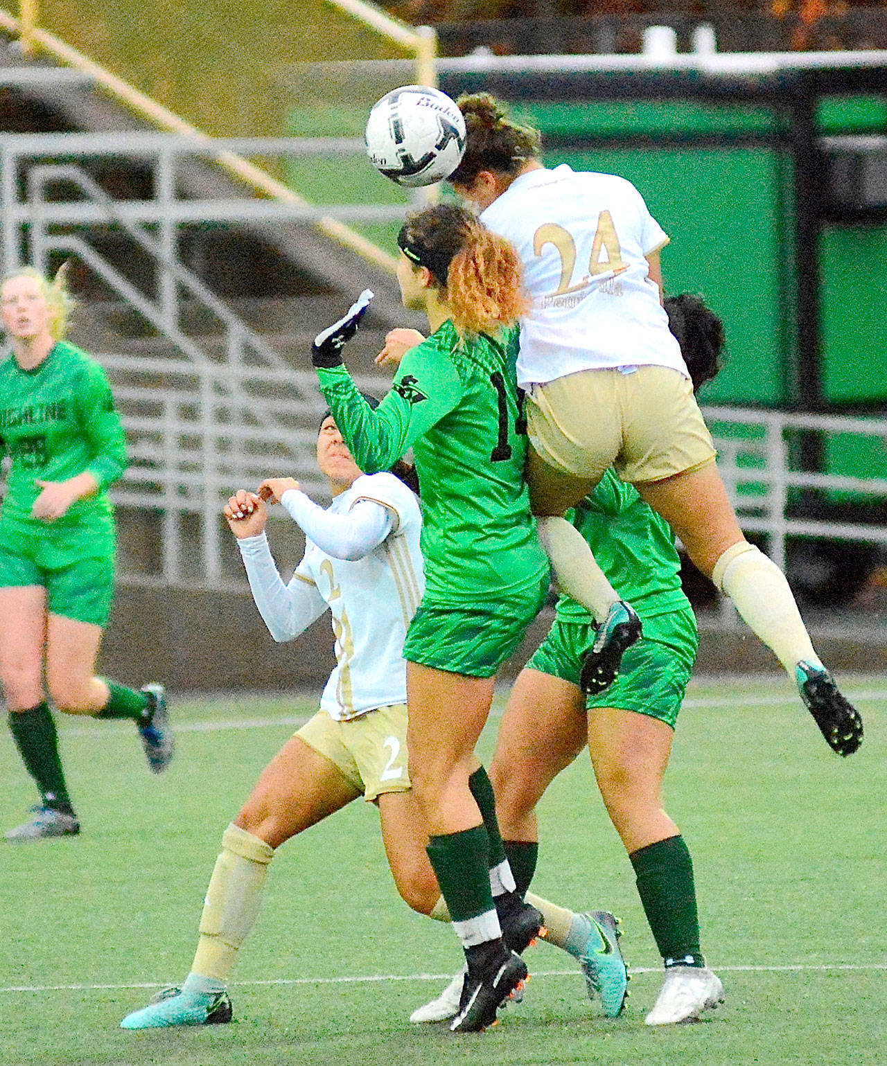 Peninsula’s Janis Martinez-Ortiz (24) leaps high to head a ball against Highline in the Northwest Athletic Conference title game Sunday. Also in oin the play is Peninsula’s Brianna Duran (2). Highline scored in overtime to win 1-0. (Jay Cline/for Peninsula Daily News)
