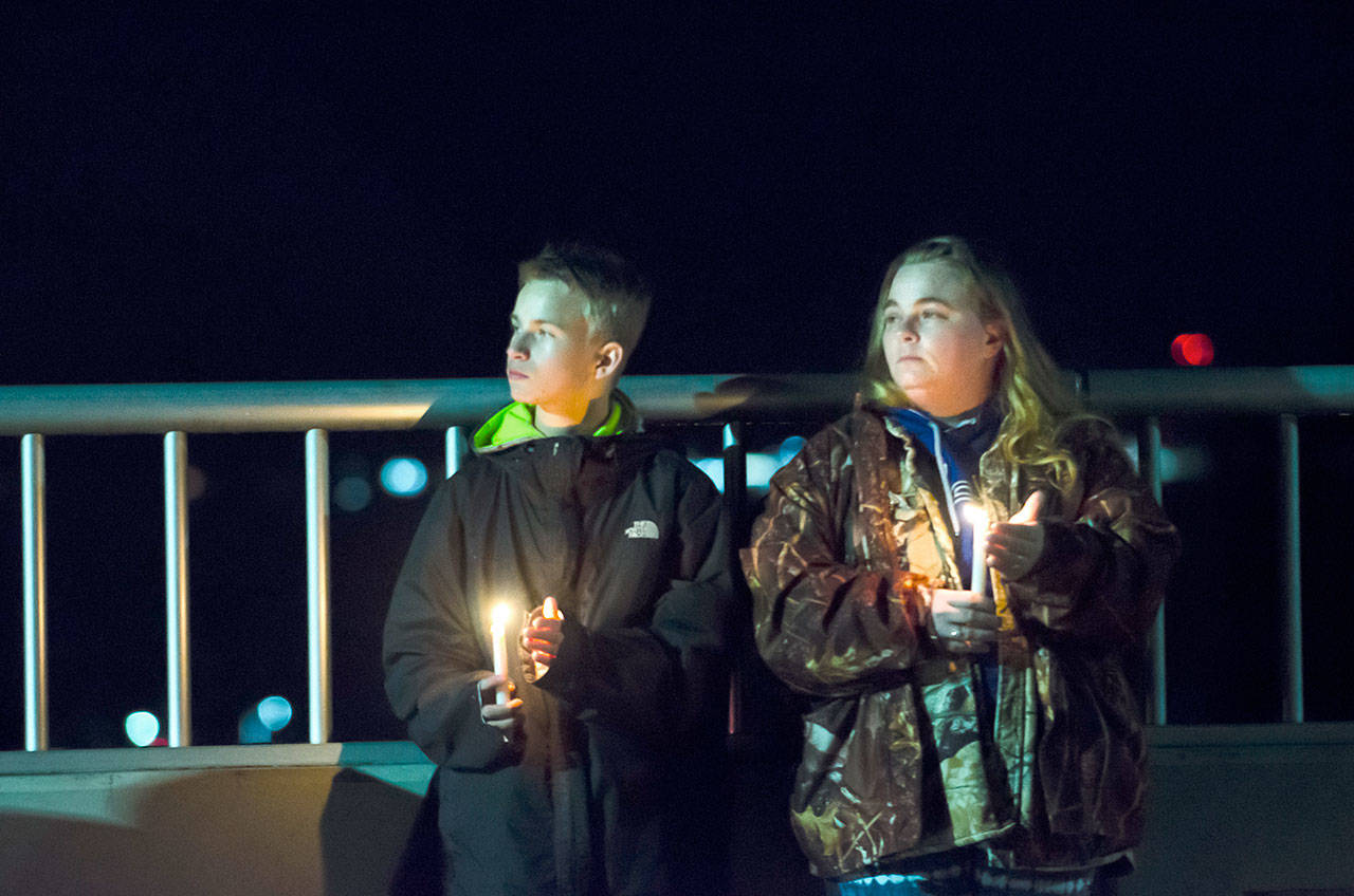 Nikki Drake and her son, Logan Leffel, attend a vigil on the Eighth Street bridge over Valley Street on Monday after Ashley Wishart, 15, jumped to her death earlier in the day. (Jesse Major/Peninsula Daily News)