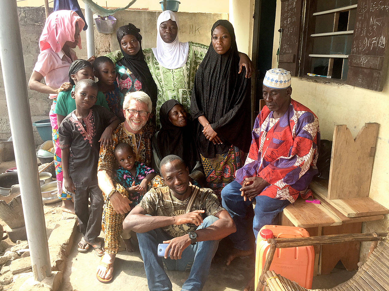 Doc Reiss poses with members of Taouvik Boukaris family. Standing at top left is Taouviks sister, Boudia, and her four children. To Boudias left are Taouviks sisters Ameeda and Smiah. Standing to the right of Smiah is Taouviks second mother Nime. Reiss is seated with Taouviks mother Fousema. Taos father, Salaj, is seated on the bench and Taouvik is in front.