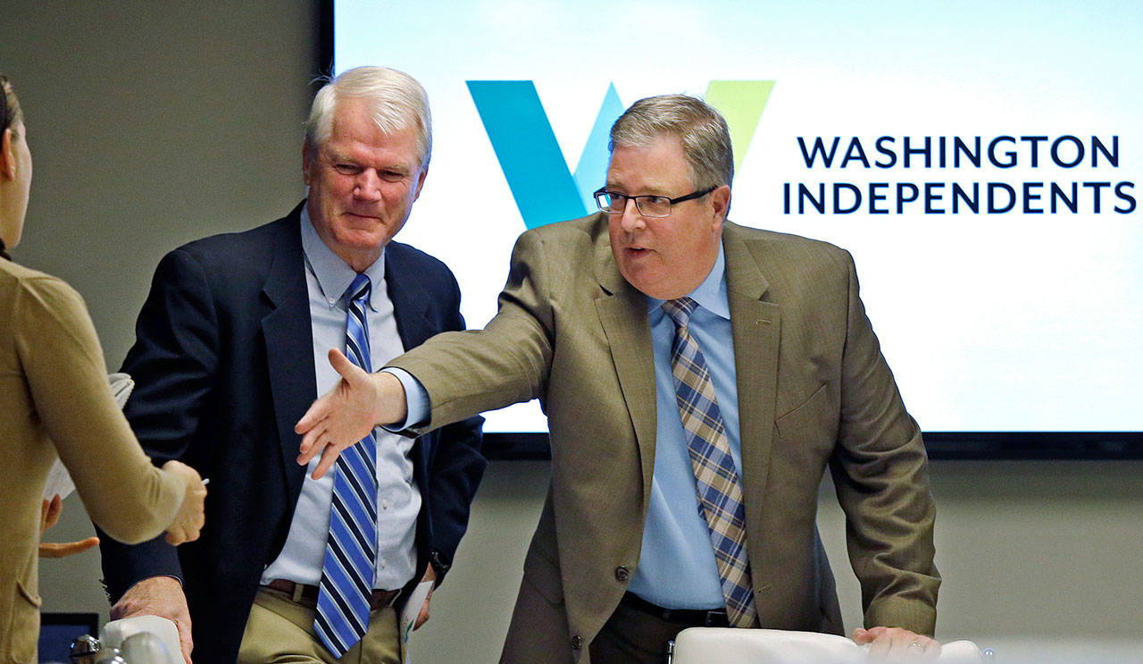 Former Democratic Congressman Brian Baird, left, and former Republican state Rep. Chris Vance greet a reporter before a news conference Thursday in Seattle. (Elaine Thompson/The Associated Press)