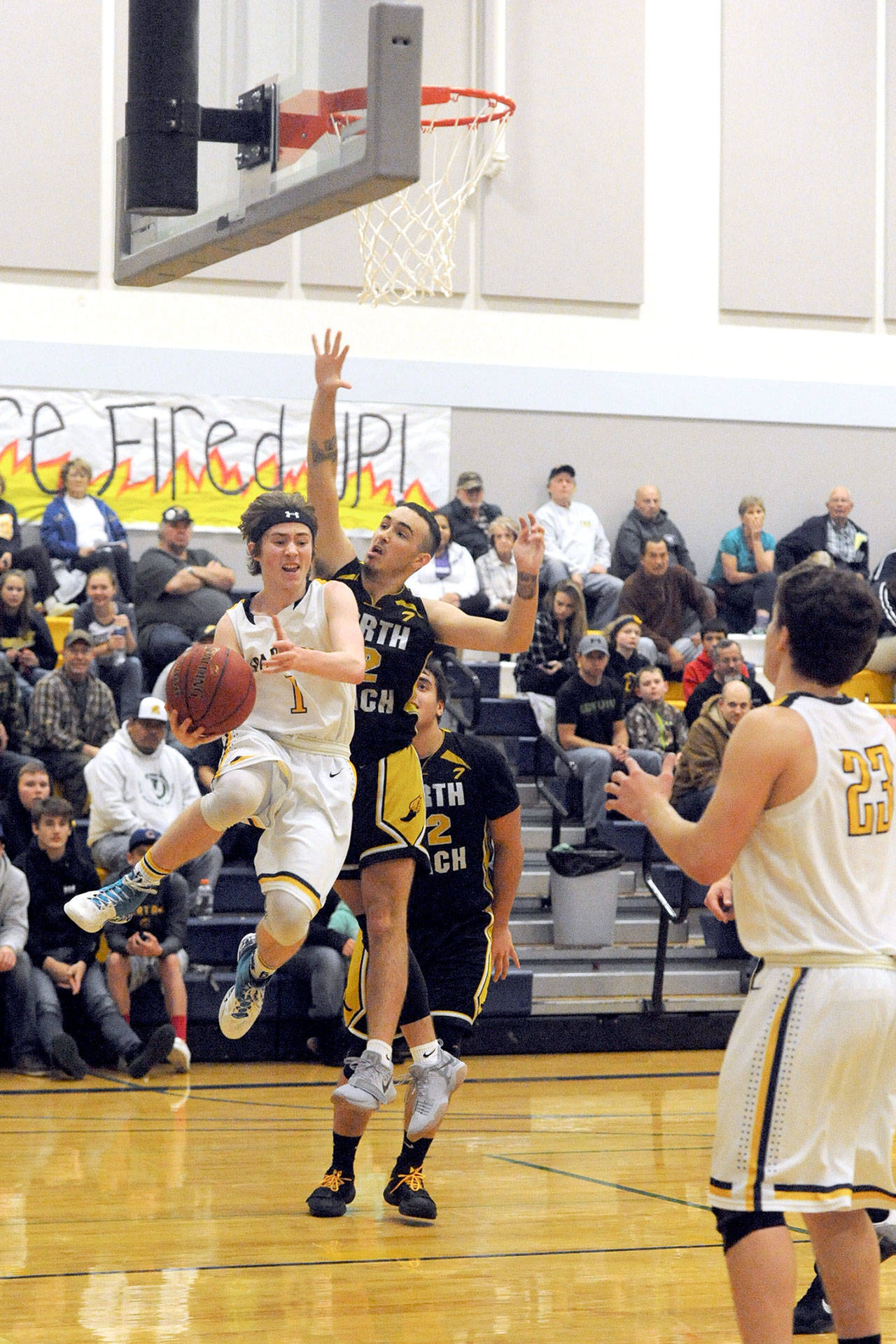 Lonnie Archibald/for Peninsula Daily News Forks’ Seth Johnson drives around North Beach’s Steven Sotomish during the Spartans’ 60-43 win over the Hyaks on Tuesday night.