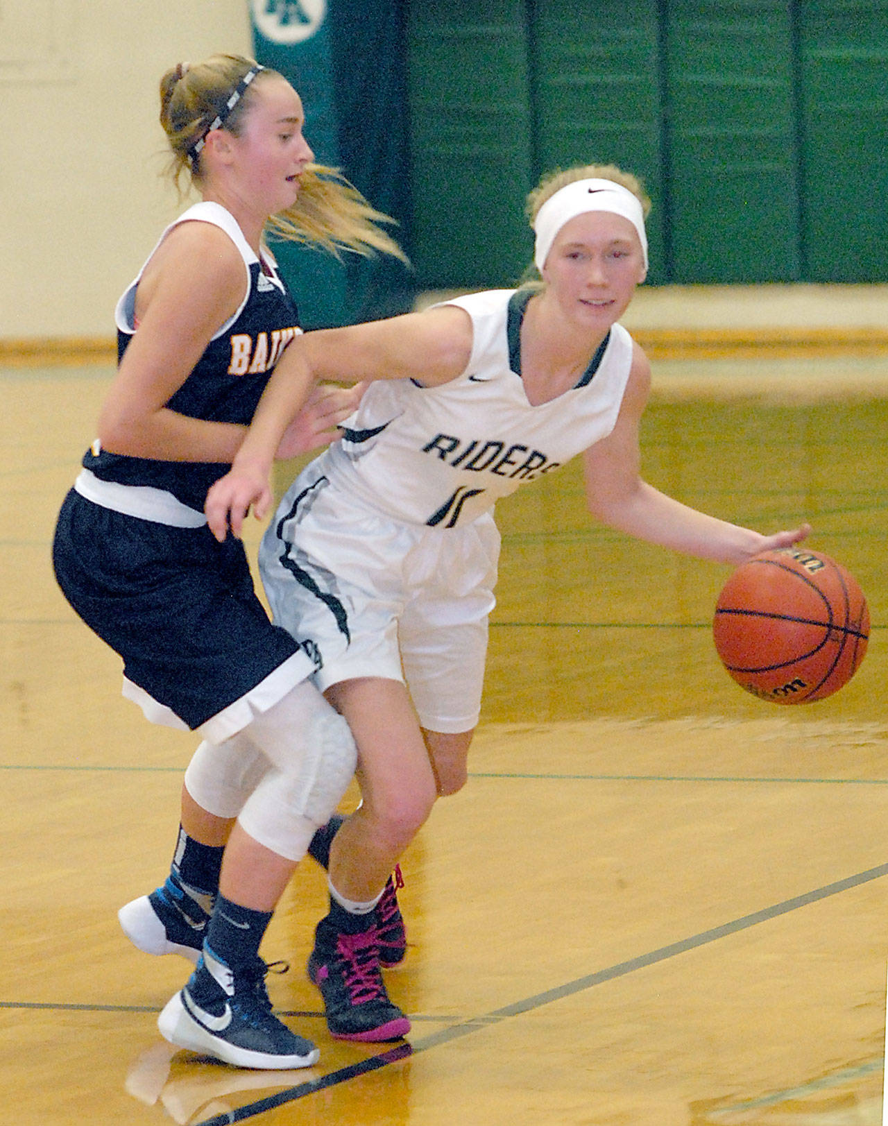 Keith Thorpe/Peninsula Daily News Port Angeles’ Gracie Long drives down court past the defense of Bainbridge’s Ellie Woolever in the second quarter on Wednesday at Port Angeles High School.