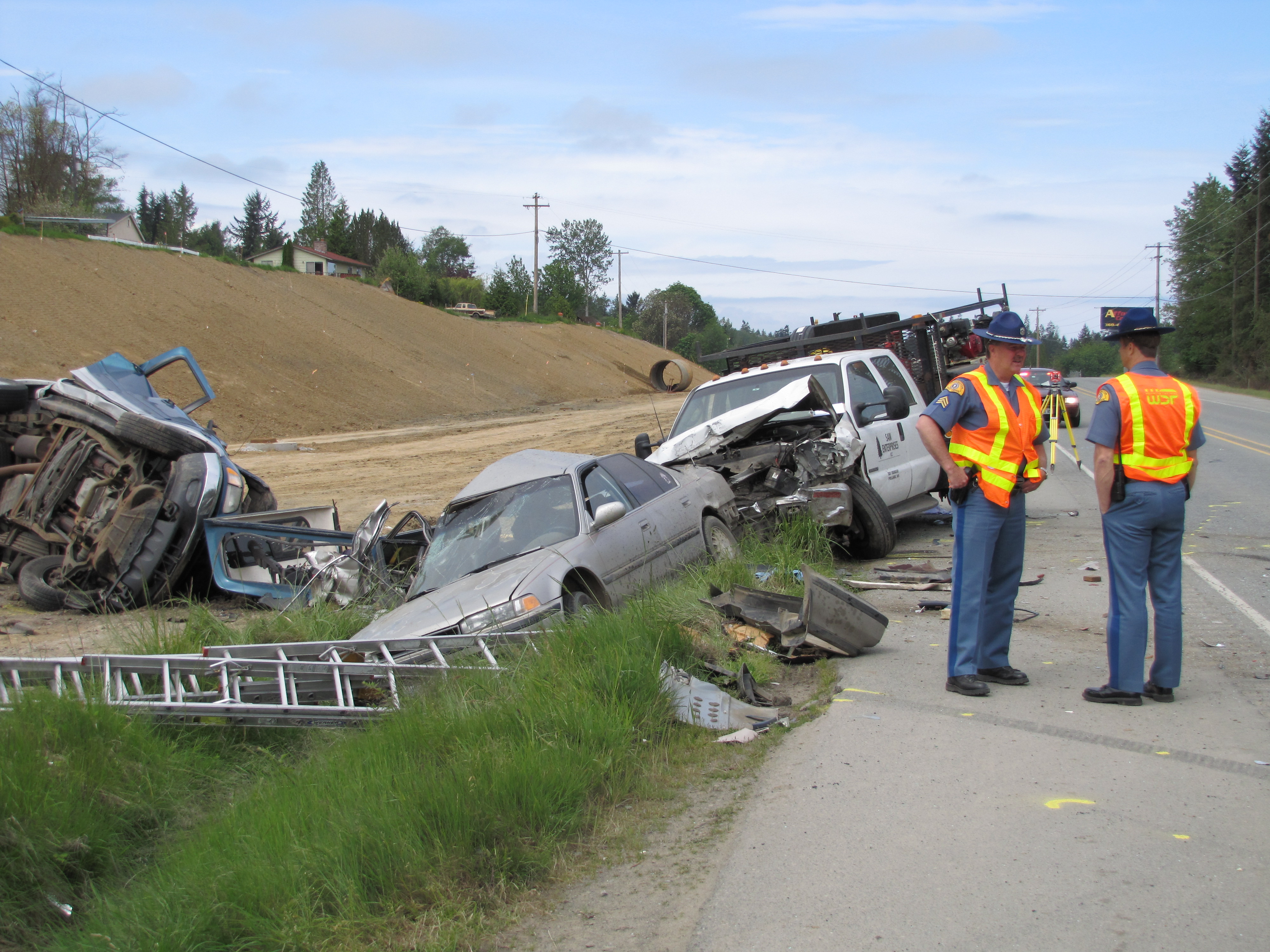State troopers discuss the scene in which two trucks and a car collided on U.S. Highway 101 between Port Angeles and Sequim this morning. Arwyn Rice/Peninsula Daily News