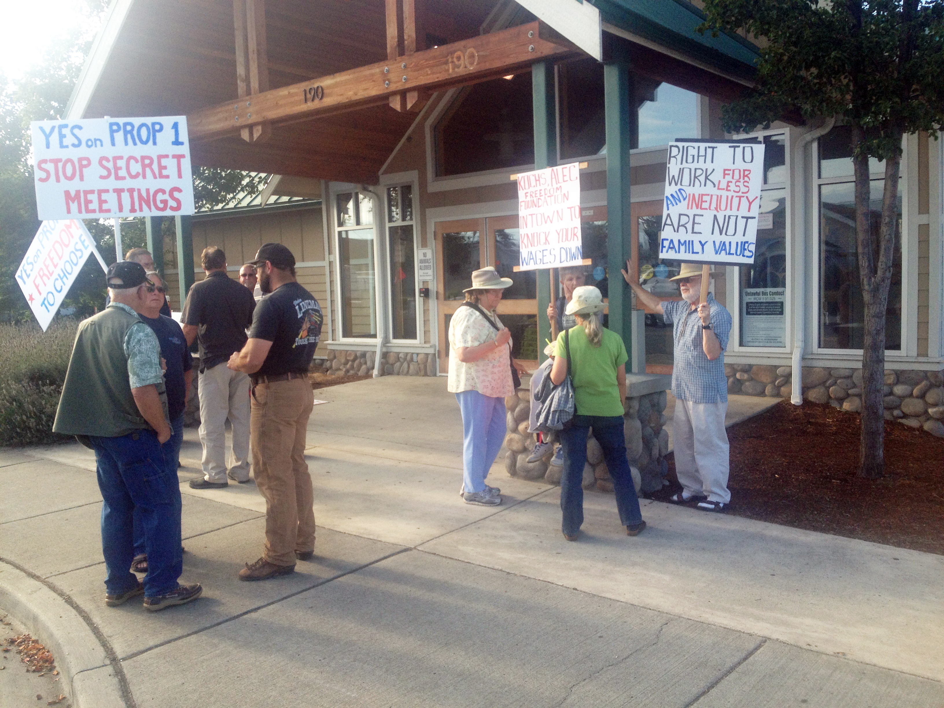 Activists on both sides of the issue picket in front of the Sequim Transit Center before Monday night's Sequim City Council meeting. Joe Smillie/Peninsula Daily News (Click on photo to enlarge)
