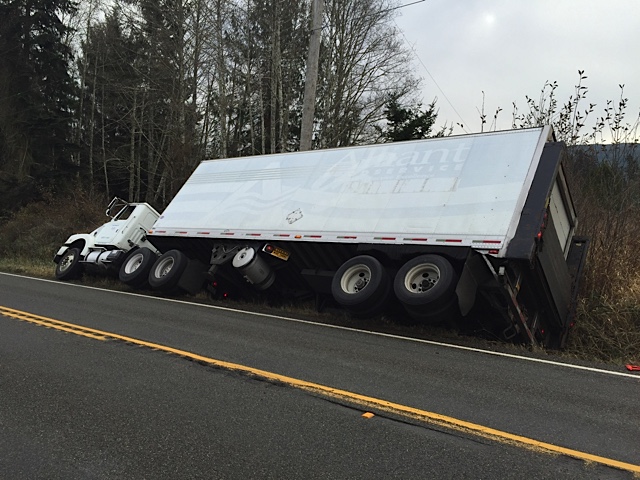 Power was shut off Wednesday for 132 Joyce customers as a safety measure while this truck was pulled from a ditch near Gossett Road west of Joyce on state Highway 112. Greg Waters/Clallam Fire District 4