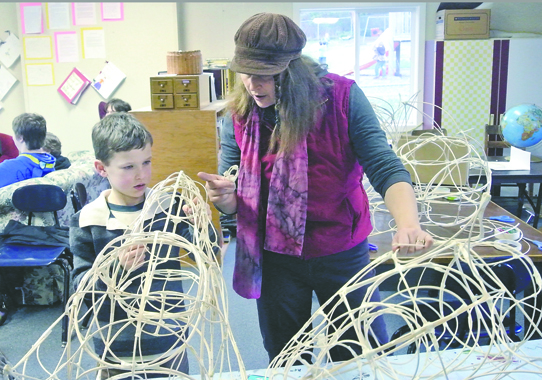 Lisa Doray shows Grant Street Elementary student Ellijah Eickmeyer how to make a dog's head for the upcoming production of "The Odyssey