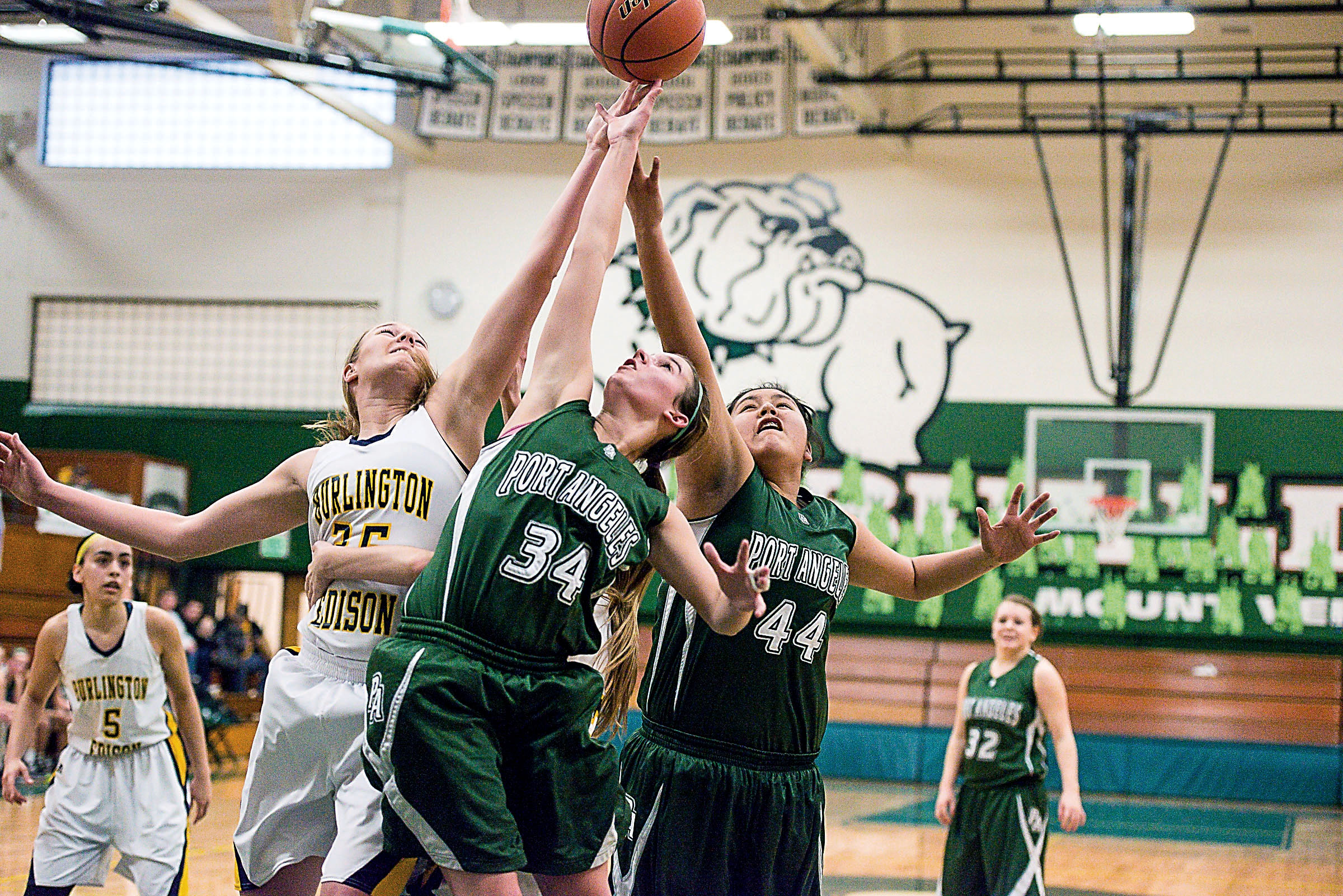 Port Angeles' Kylee Jeffers (34) and Nizhoni Wheeler (44) battle Burlington-Edison's Emily Agen for control of a errant pass by Burlington-Edison during the Roughriders' 54-46 regionals win last week at Mount Vernon High School. The Riders open the state tournament today against Lynden at the Yakima SunDome. Amylynn Richards/for Peninsula Daily News