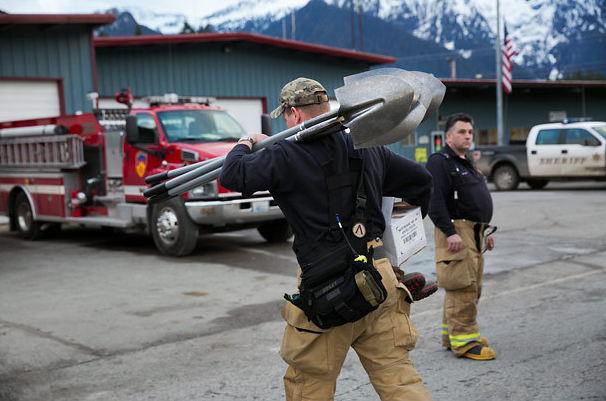 Firefighters help unload publicly donated equipment to aid the search and rescue operations in the aftermath of the massive mudslide. The Asociated Press