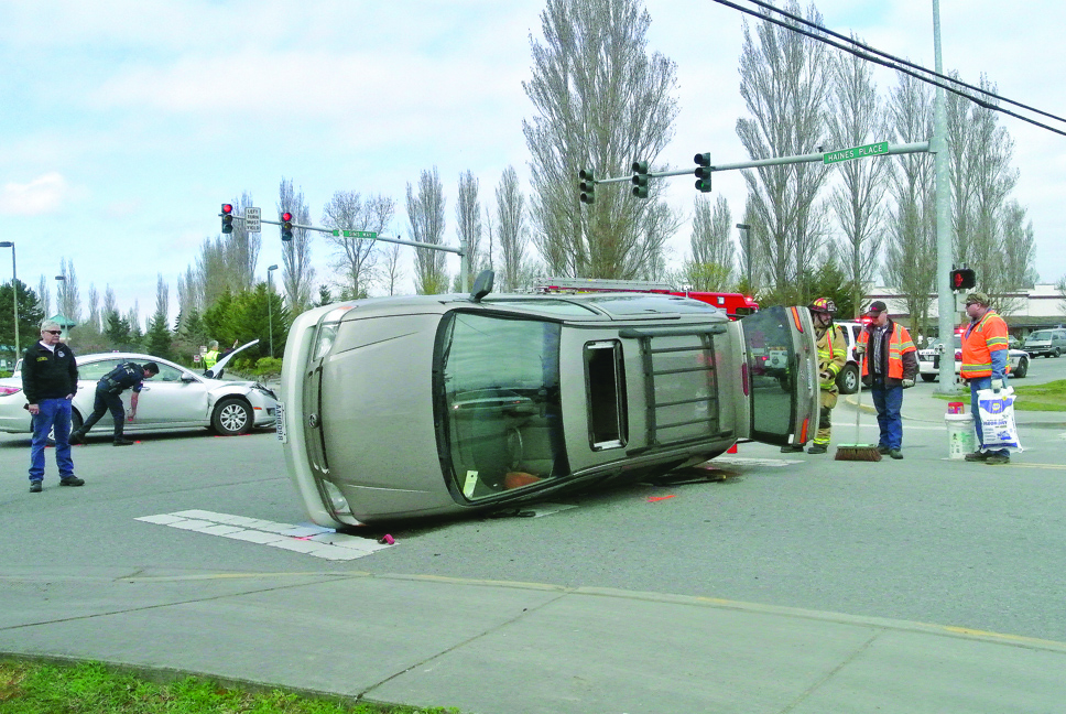 A Toyota Sienna van lies on its side Monday afternoon folllowing a collision in Port Townsend. Charlie Bermant/Peninsula Daily News