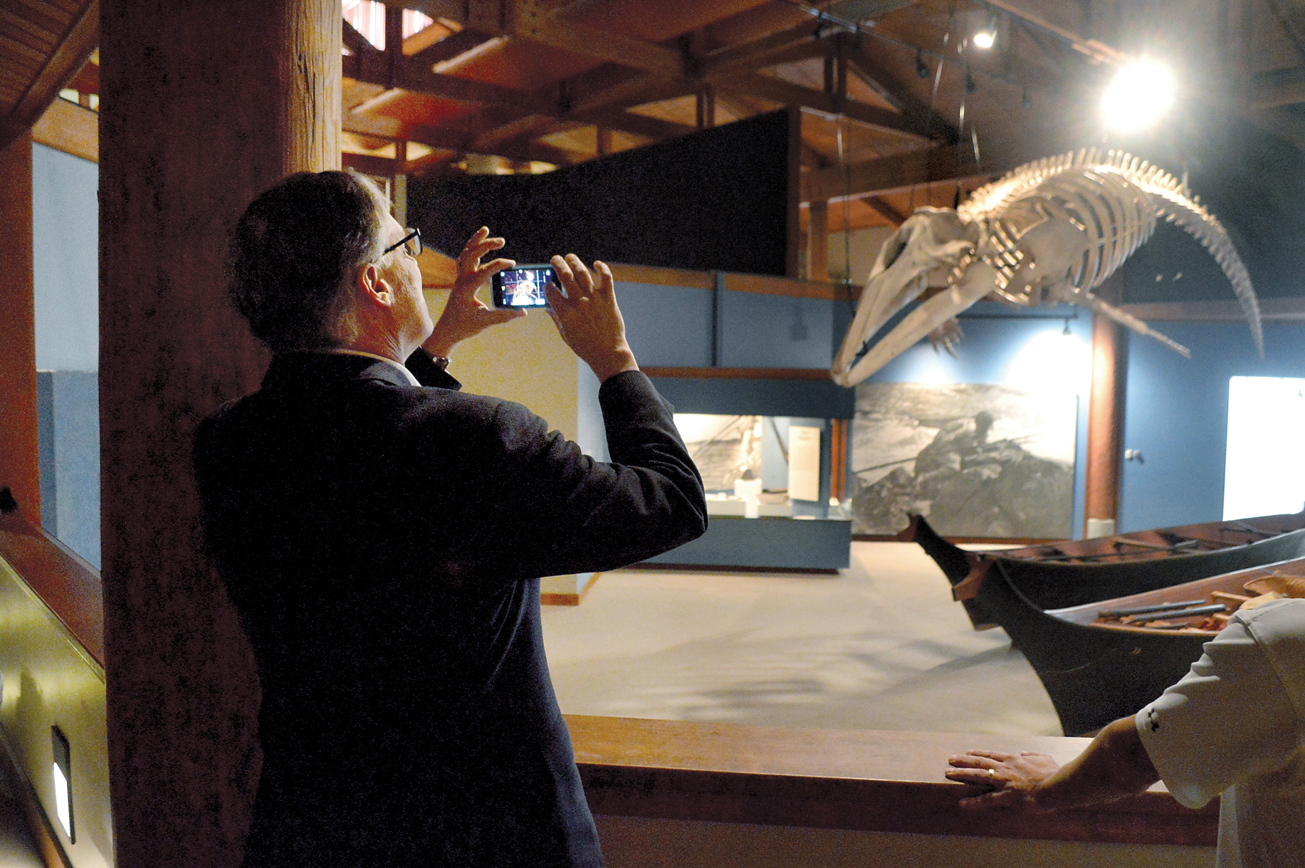 Gov. Jay Inslee snaps a photo of the skeleton of a gray whale hunted by Makah whalers in 1999 during a visit to the Makah Museum on Friday.  — Photo by Joe Smillie/Peninsula Daily News