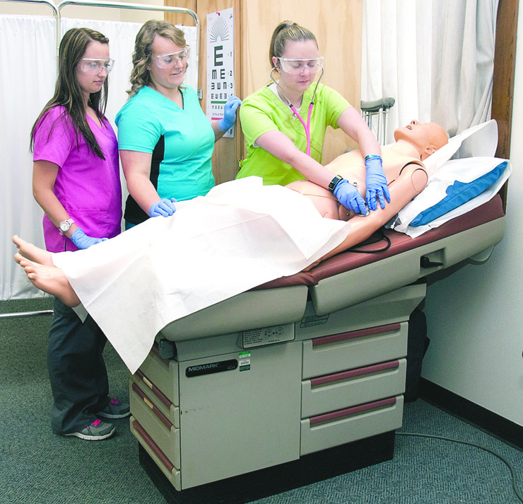 A new exam table is put to use by Medical Assisting Program students