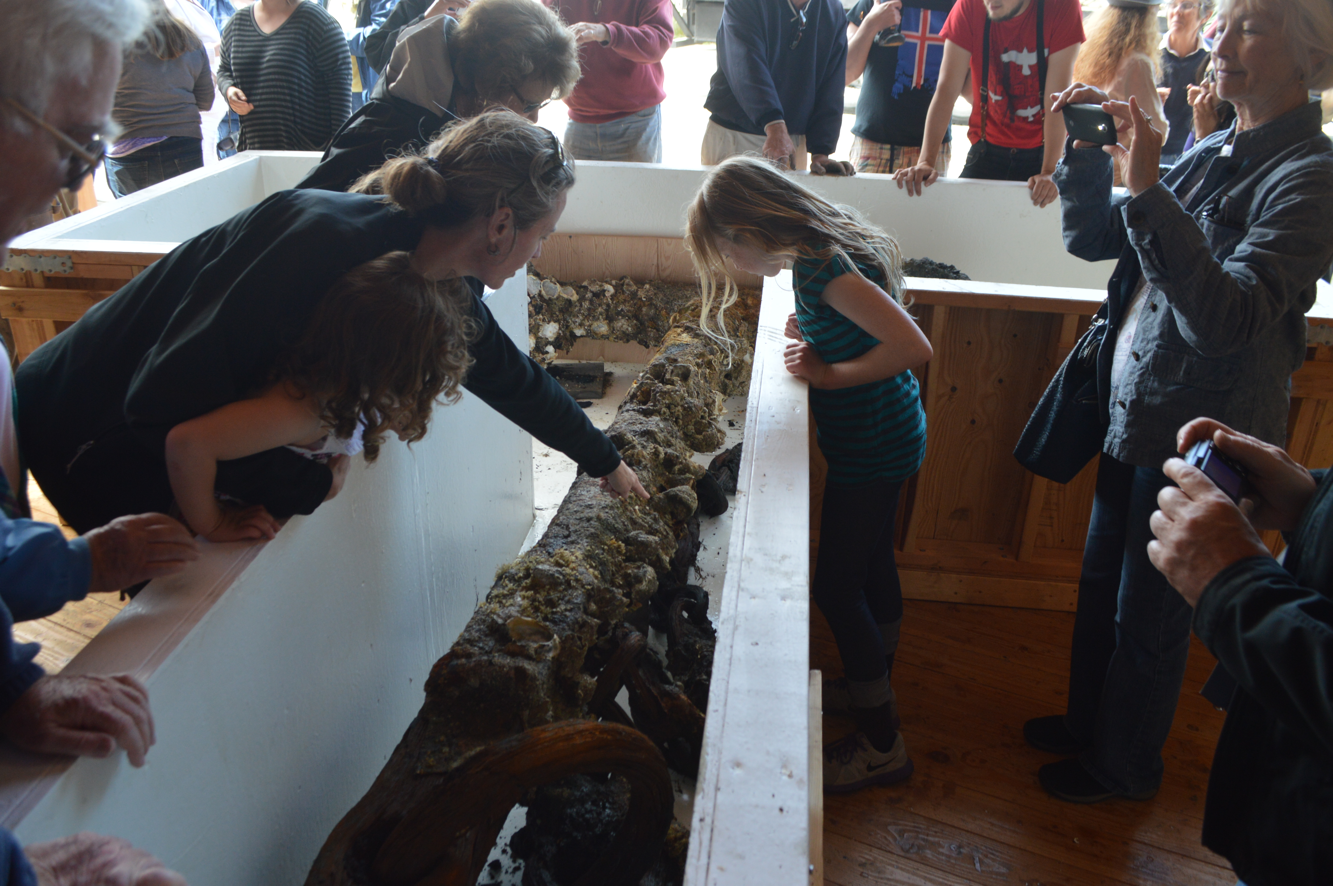 First-day crowds at the Northwest Maritime Center in Port Townsend examine the anchor in its specially constructed display case. Joe Smillie/Peninsula Daily News