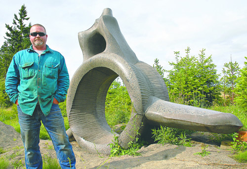 Alex Anderson of Port Angeles is the creator of this 16-foot-long whale vertebra sculpture. Chris Tucker/Peninsula Daily News