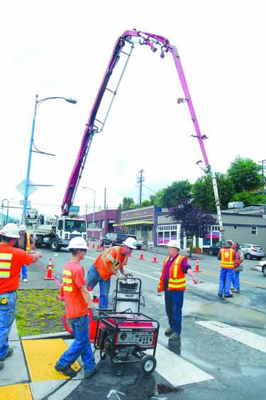 Crews from the state Department of Transportation and the Port Angeles street department bring in a concrete pumping rig and a vacuum to draw up rainwater in an attempt to fill a cavity discovered beneath Lincoln Street. Keith Thorpe/Peninsula Daily News