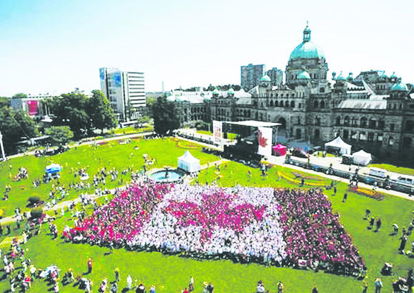 Mayor Cherie Kidd was among those creating a human Canadian flag on Canada Day in Victoria. The Associated Press