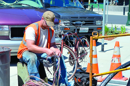 CenturyLink contractor Aaron Wilcox splices phone wire on Taylor Street on Thursday. Charlie Bermant/Peninsula Daily News