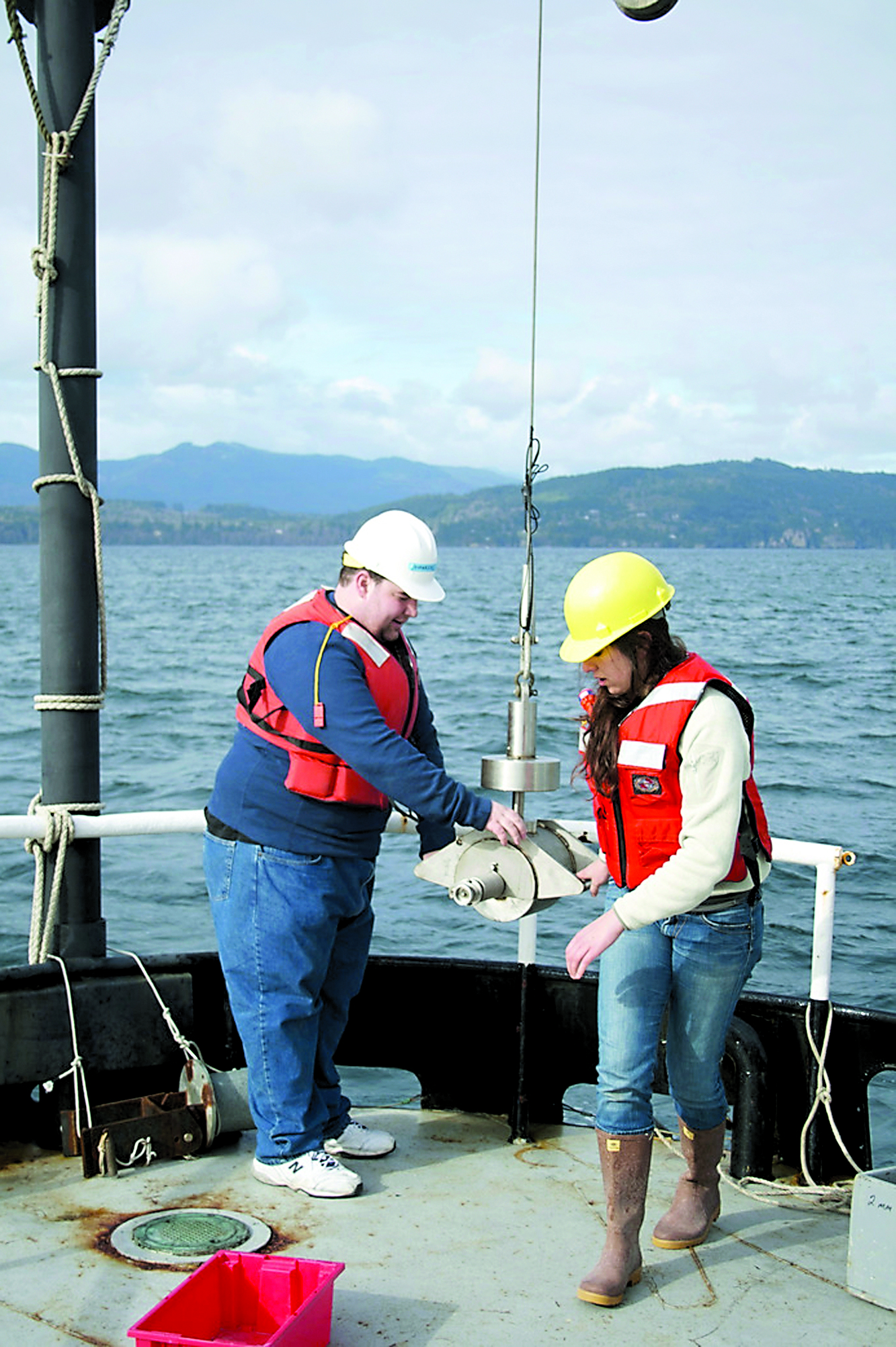 University of Washington School of Oceanography undergraduate students Evan Davies and Julia Marks gather sediments from the Strait of Juan de Fuca using a “Shipek” device onboard the RV Barnes