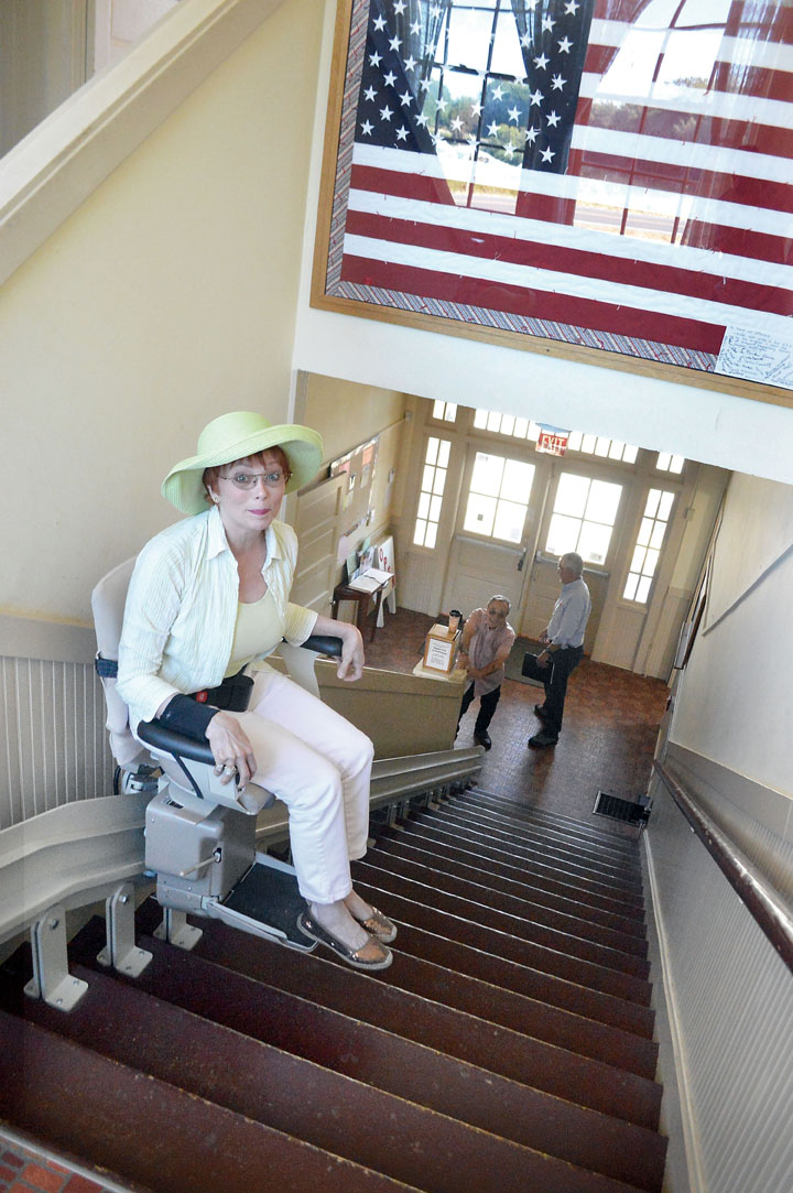 Shelley Taylor rides the chair lift she is leading an effort to replace in the Dungeness Schoolhouse. The chair ran out of power before she could make it to the top. Joe Smillie/Peninsula Daily News