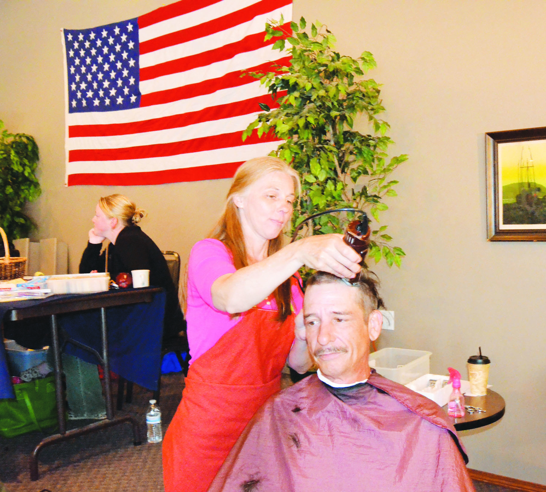 Daron Geller of Port Angles gets a haircut from Ada Isakson at Monday's Stand Down in Port Townsend. Charlie Bermant/Peninsula Daily News