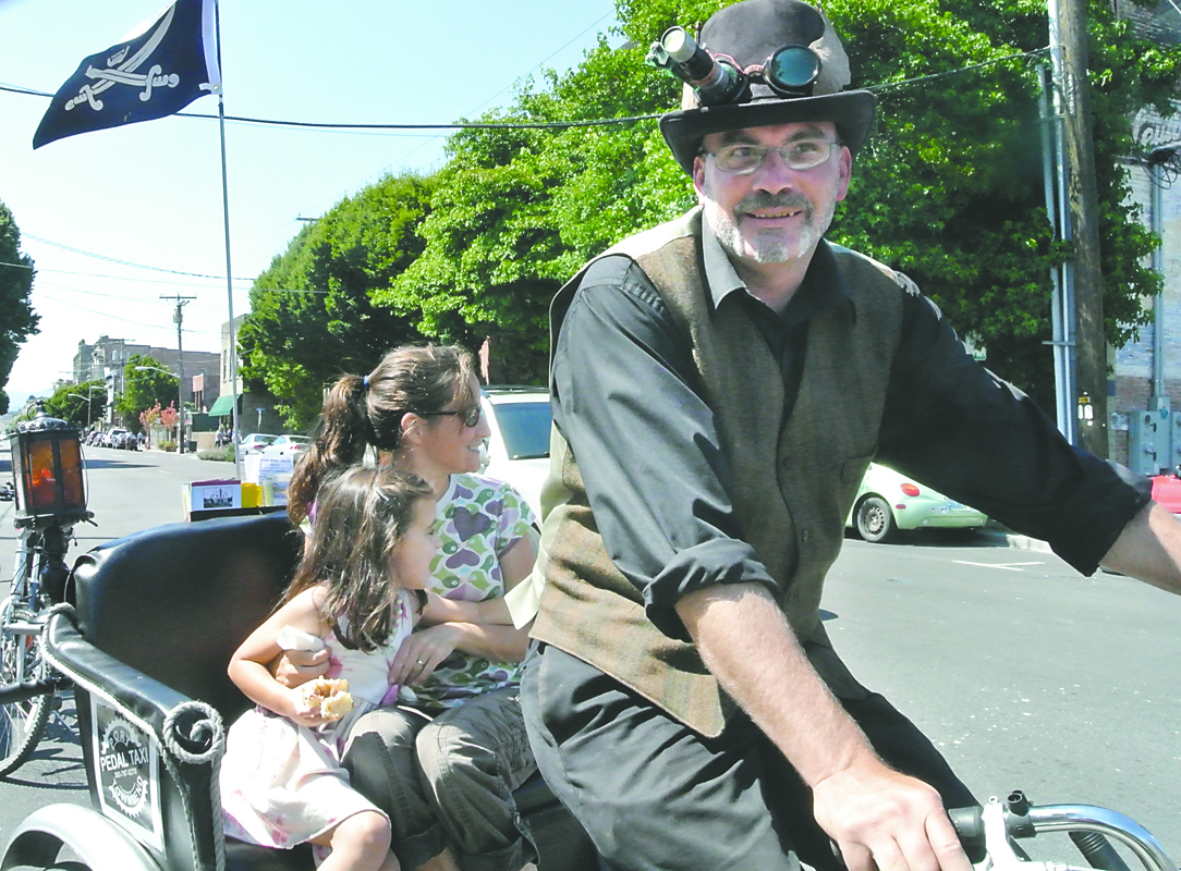 Geoff Gardner gives a ride through downtown Port Townsend to Thea Barrett