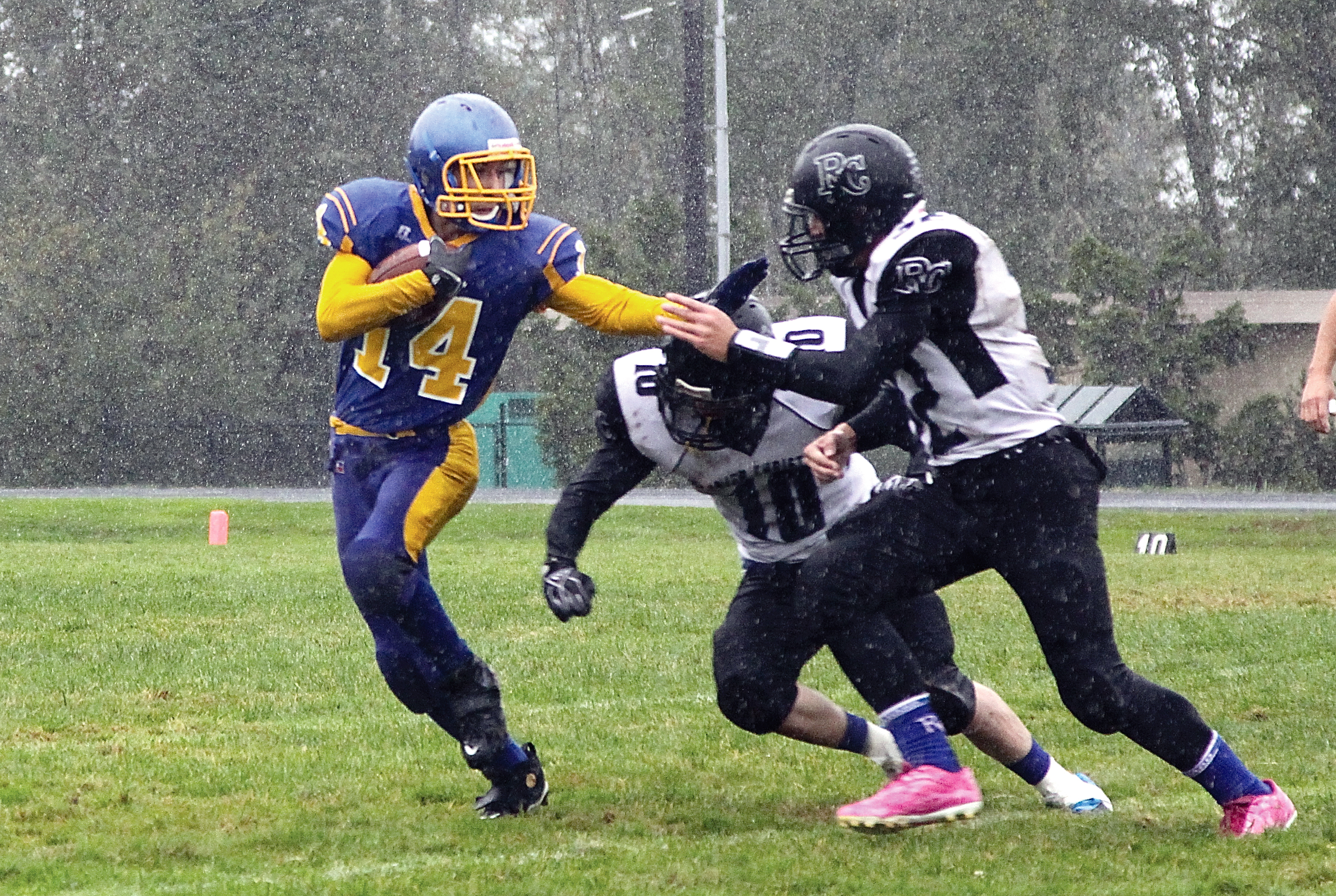 Crescent's Zach Fletcher (14) tries to get away from a pair of Rainier Christian tacklers last season. Fletcher led Crescent in all-purpose yards as a junior in 2013. Dave Logan/for Peninsula Daily News